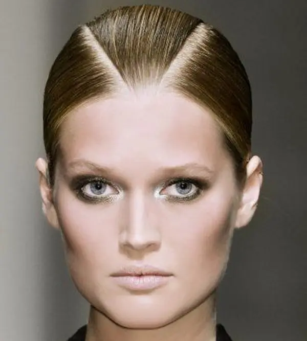 femme avec une coiffure composée de deux raies se rejoinant au centre de la tête, formant un triangle