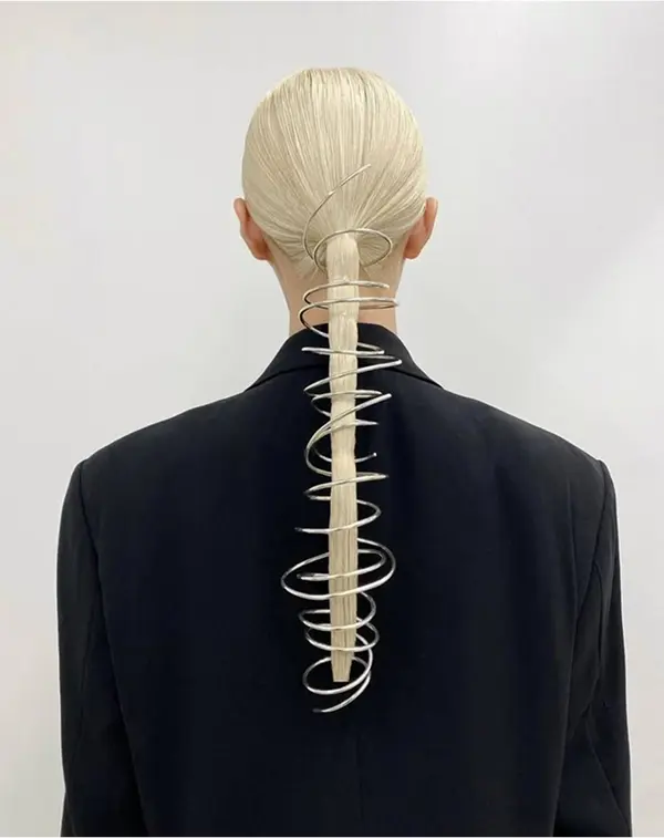 femme de dos avec une queue de cheval basse, entourée d'un fil métallique